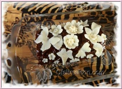 Gâteau avec nappage au chocolat et décors en pâte à modeler au chocolat blanc.