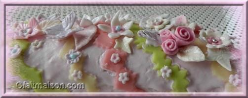 Gâteau décoré de fleurs et fleurs en ruban de pâte à sucre.