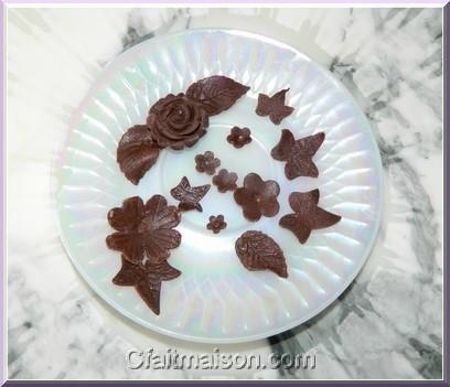 Fleurs, papillons et décors en pâte à modeler en chocolat pour décors de gâteaux.