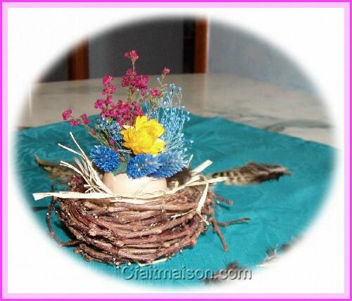 Faux petit nid en vigne vierge avec un œuf décoré de fleurs séchées.
