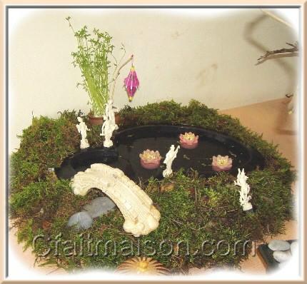 Petit bassin miniature avec lentilles d'eau, nnuphars bougies, mousse, galets, pont, graines germes de lentilles, mini lampion et petits personnages.