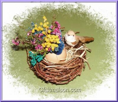 Petit nid garni avec une coquille d'oeuf remplie de mousse oasis et de fleurs sches.