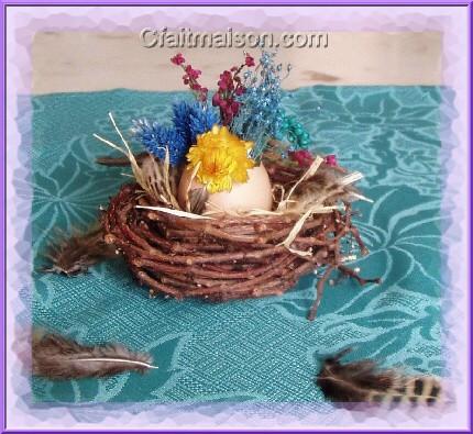 Petit nid fait maison garni avec une coquille d'oeuf remplie de mousse oasis et de fleurs sches