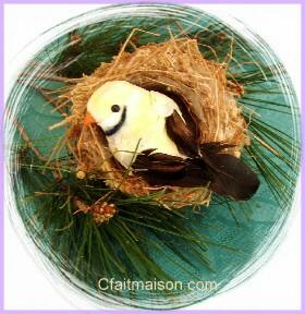 Oiseau dcoratif en plumes dans un vrai nid.