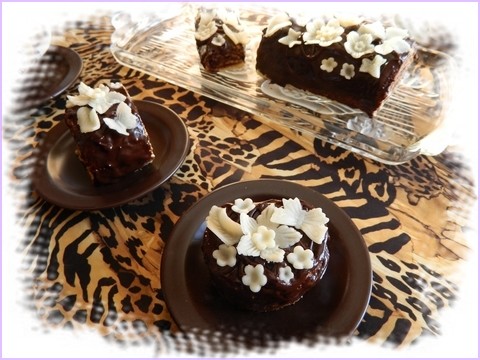Gâteaux nappé de chocolat noir avec fleurs, papillons et décors en pâte à chocolat blanc.