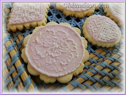 Biscuits avec glaçage royal rose et dessins réalisés sur ce glaçage en glaçage blanc.