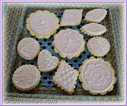 Biscuits avec glaçage royal rose et dessins réalisés sur ce glaçage en glaçage blanc.