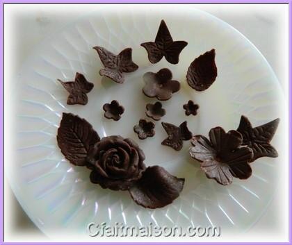 Fleurs, papillons et décors en pâte à modeler en chocolat pour décors de gâteaux.